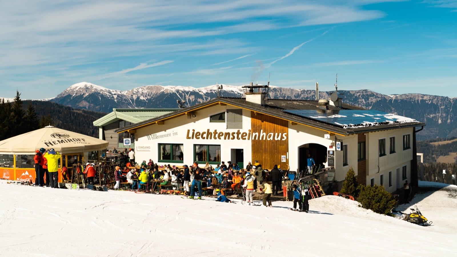 Liechtensteinhaus im Winter — Sonnenterrasse am Gipfel mit Schnee und Skifahrern
